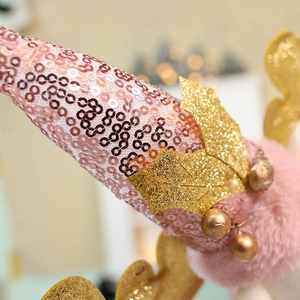 Detail of pink sequined Christmas ornament with golden glitter leaves and small bells