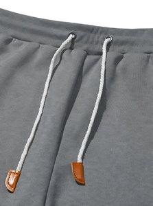 Detailed close-up of grey joggers waist with elastic band and white drawstring