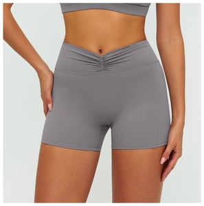 Detail of high waisted yoga shorts featuring a V-shaped crossover waist and grey fabric
