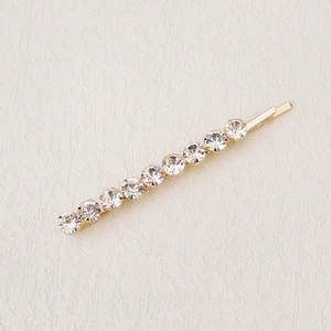 Detailed macro view of a golden hair clip with shimmering inlaid crystal rhinestones