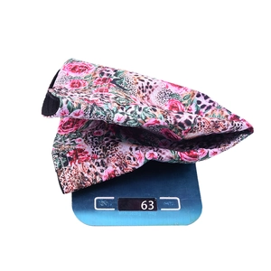 Detail showing the floral leopard print bucket hat weighing approximately 63g on a scale