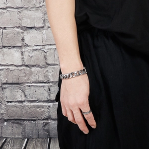 Nahaufnahme von silbernem Panzerarmband und geflochtenem Ring am Handgelenk