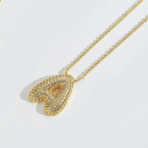 Detail of gold twisted chain with a puffy letter A pendant set in sparkling rhinestones