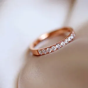 Close-up of rose gold titanium ring with a half band of sparkling pavé-set zircons