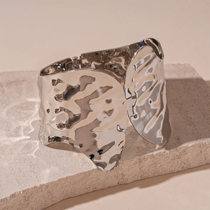 Macro detail of silver irregular textured bangle showing ripple metal finish on stone