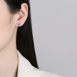925 silver heart stud earrings with red zircon and sparkling white stones on a model