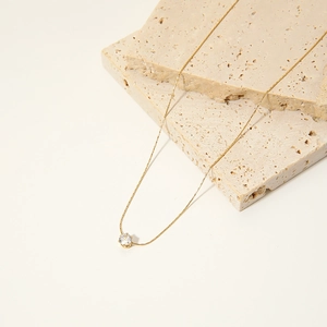 Minimalist gold necklace with a round sparkling solitaire zircon pendant in a claw setting