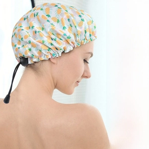 Detail of waterproof shower cap with pineapple print and adjustable black elastic buckle
