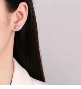 Macro detail of a 925 silver camellia flower stud earring worn on the earlobe