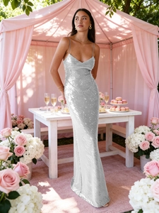 Robe à paillettes argentées dos nu avec fines bretelles dans un décor de jardin élégant