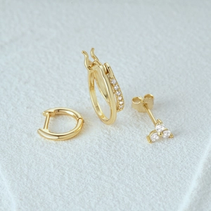 Macro detail of three-piece 925 sterling silver gold earring set with zircon accents