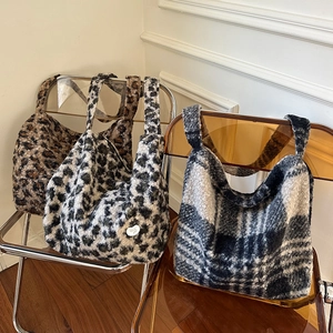 Faux fur leopard print large tote bags and plaid crossbody purses displayed on a chair