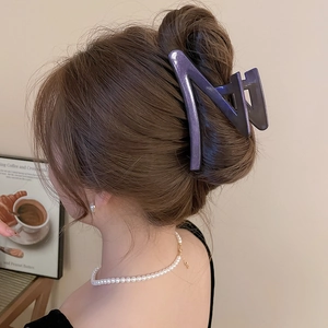 Acrylic purple gradient bow shark hair clip with glitter finish shown on a model's hair