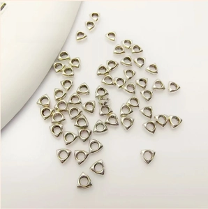 Close-up of antique silver triangle spacer beads for DIY jewelry making on white background