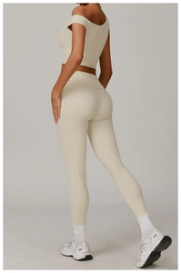 Vue latérale de l'ensemble de yoga crème avec haut asymétrique et legging