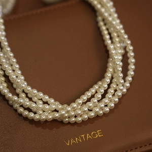 Elegante collana di perle bianche multistrato a cinque fili su sfondo in pelle pregiata