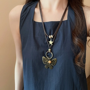 Close-up of retro bronze butterfly pendant necklace with wooden beads and woven wax cord