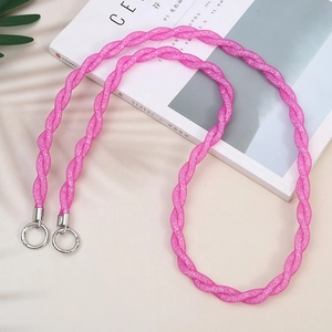 Pink braided mobile phone lanyard with silver metal clasps on a stylish magazine
