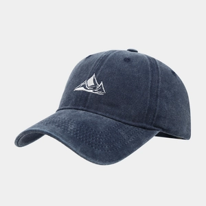 Detailed close-up of mountain embroidery and stitched fabric on navy washed cotton cap