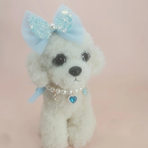 Detail of light blue sequin bow hairclip and pearl necklace with heart pendant on dog
