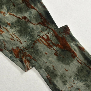 Dettaglio della trama del tessuto in velluto tie-dye grigio scuro e rosso ruggine