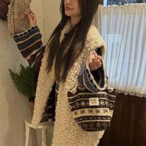 Detail of plush lamb wool handbag with ethnic patterns and white brand label on front