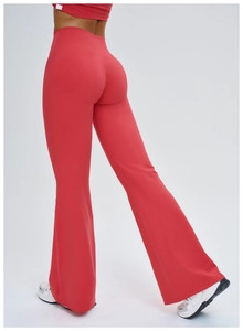 Gros plan sur le pantalon de yoga évasé rouge à taille haute et sa coupe ajustée
