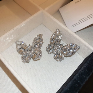 Orecchini a farfalla in argento con zirconi scintillanti su un vassoio per gioielli