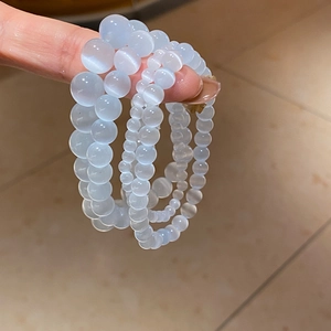 Detail of layered cat-eye stone beads showing semi-transparent blue and white tones