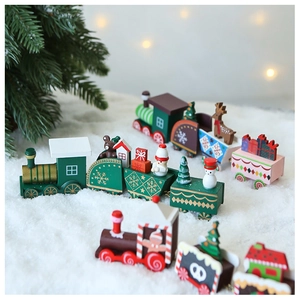 Wooden Christmas train toy with snowman and trees on artificial snow background