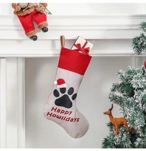 Red and beige pet paw Christmas stocking with Happy Howlidays text on fireplace mantle