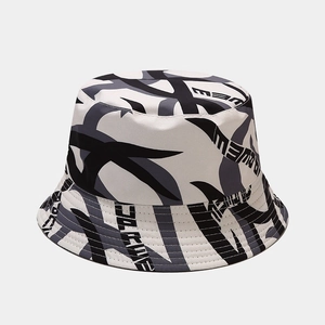 Gros plan du motif vache abstrait et du lettrage stylisé sur le chapeau bob en toile