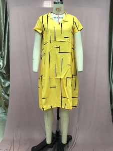 Detailed view of yellow V-neck dress with abstract black lines on a mannequin