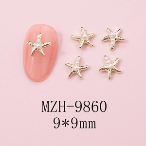 Detailed macro view of 9mm gold starfish nail art charms with pearls on pink background