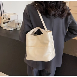 Chic cream white leather tote bag shown on model for a trendy commuting outfit style