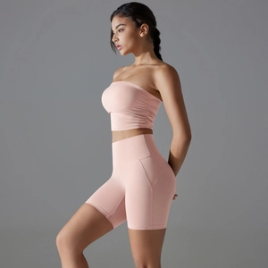 Detailed side view of pink high-stretch yoga bra and high-waist biker shorts set