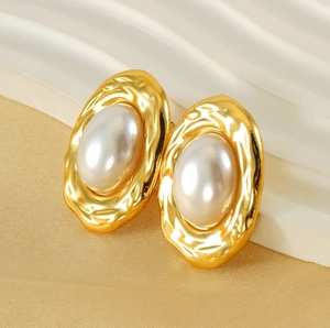 Macro view of gold heart oval earrings featuring irregular hammer texture and pearls