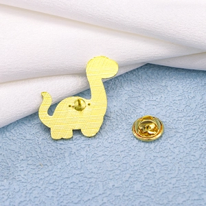 Pin's dinosaure doré avec texture détaillée au dos et fermoir papillon sécurisé