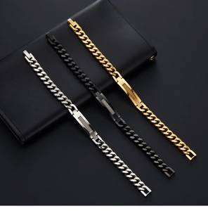 Detailed close-up of Cuban link bracelets in silver, black and gold over a leather wallet