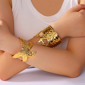 Golden starfish relief and hammered texture open bangles set on woman wrist