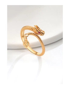 Macro detail of golden dragon ring featuring clear scales, red eyes and a leaf charm