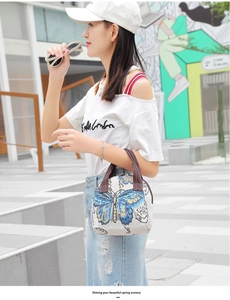 Detailed view of the woven butterfly pattern and ethnic striped handle on the beige bag