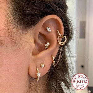 Close-up of S925 sterling silver marquise stud earring on ear with gold plating and crystals