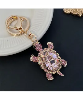 Close-up of cute turtle keychain with pink crystals and gold-plated metal link