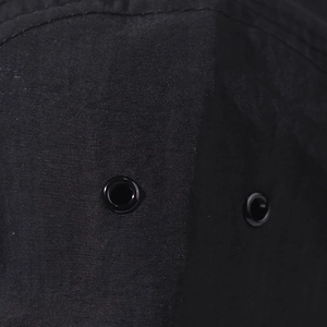 Macro detail of breathable metal eyelets on a black quick-dry outdoor sun protection cap