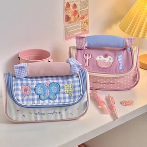 Detail of cute canvas pencil cases with embroidery and handles in a cozy desk setting