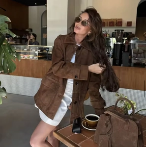 Fashionable brown suede jacket and matching tote bag in a cozy cafe setting
