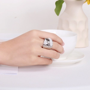 Detailed view of silver crossover ring featuring pavé-set crystals on model's hand