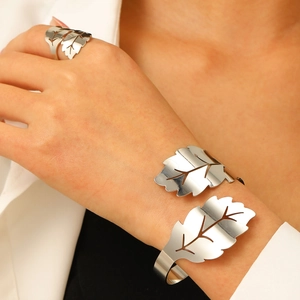 Detalle de conjunto de joyería de hoja plateada con brazalete abierto y anillo ajustable