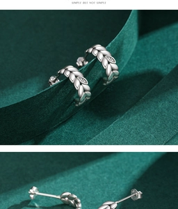 Detail of s925 silver leaf earrings with clear crystals on green velvet ribbon